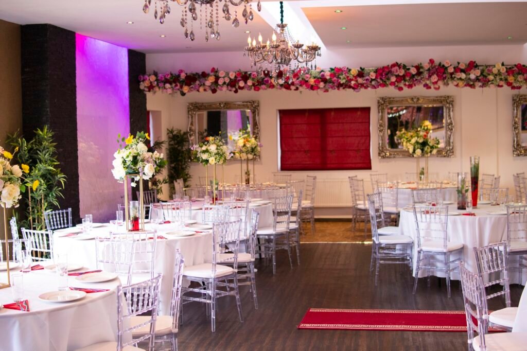 Elegant wedding reception setup at The Maison Bradford with round tables, floral centrepieces, and crystal chandeliers.