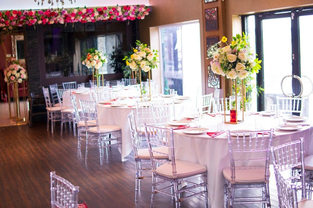 Table layout with floral centrepieces inside The Maison Bradford, showing the bright event space used for viewings, bookings, and in-person tours.