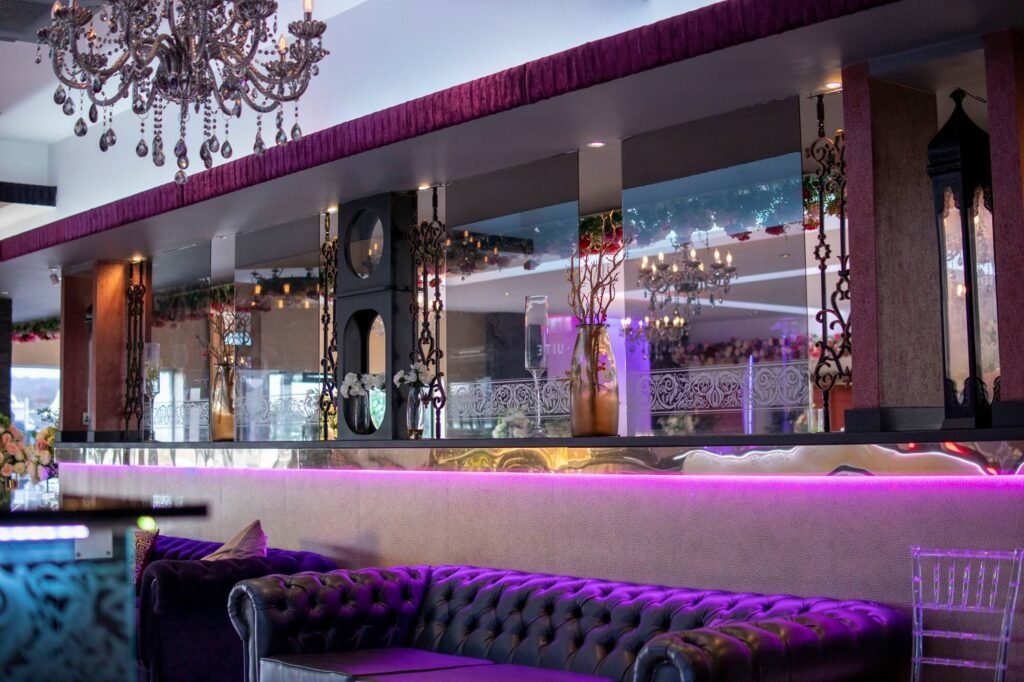 Luxury guest lounge and bar area at The Maison, one of the premier event venues in Bradford with plush seating and chandeliers.