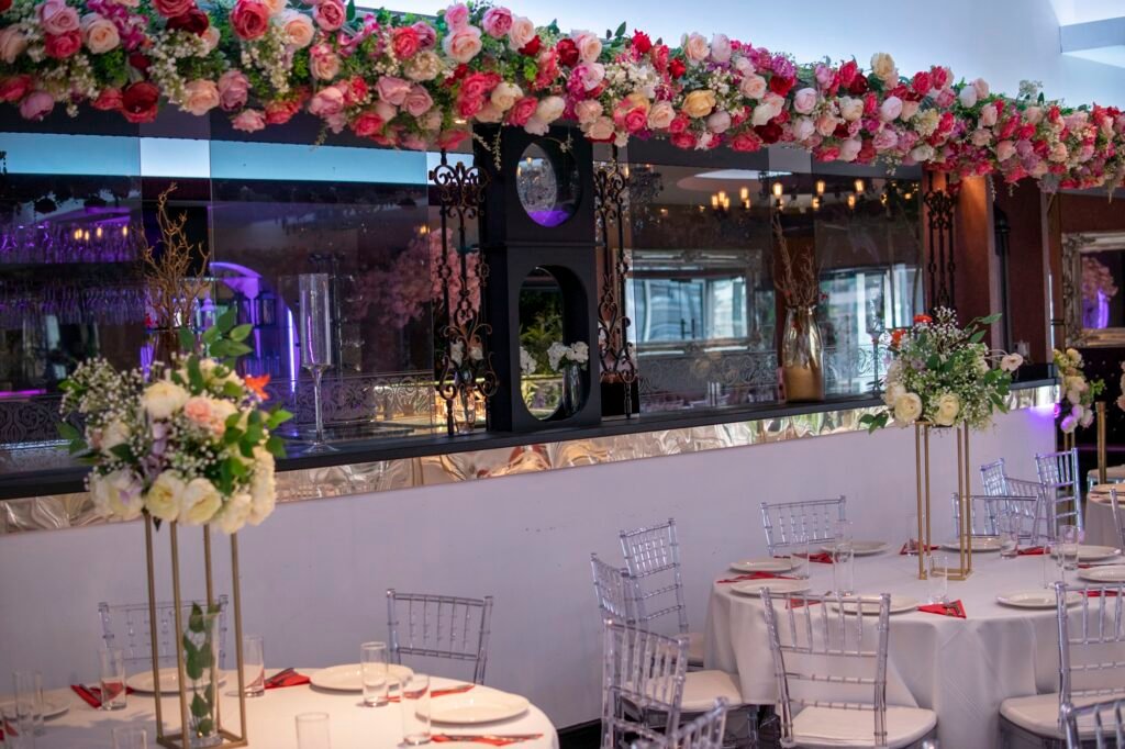 Floral stage and table decor for a Pakistani wedding celebration.