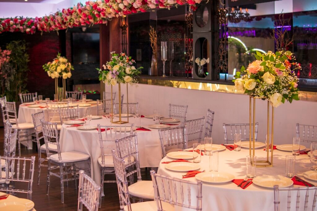 uxury Banqueting Hall Bradford set up for a wedding reception with floral centerpieces and Chiavari chairs.