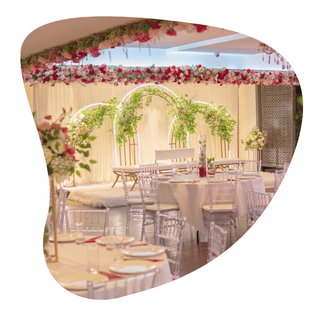 Wedding ceremony and reception setup at The Maison Bradford with floral arches, white seating and round tables.